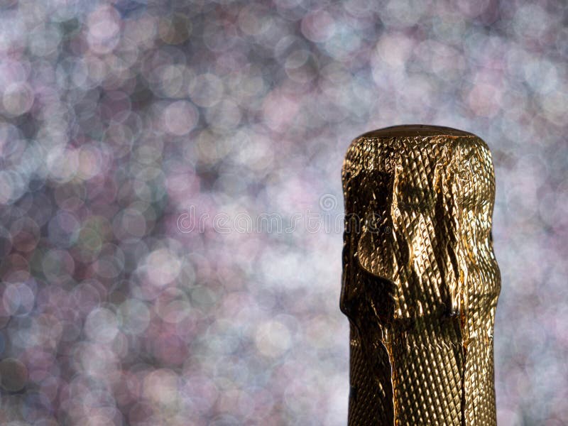 Bottle of Champagne with Gold Glitter on a Shiny Background. Stock