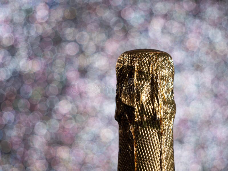 Bottle of Champagne with Gold Glitter on a Shiny Background. Stock