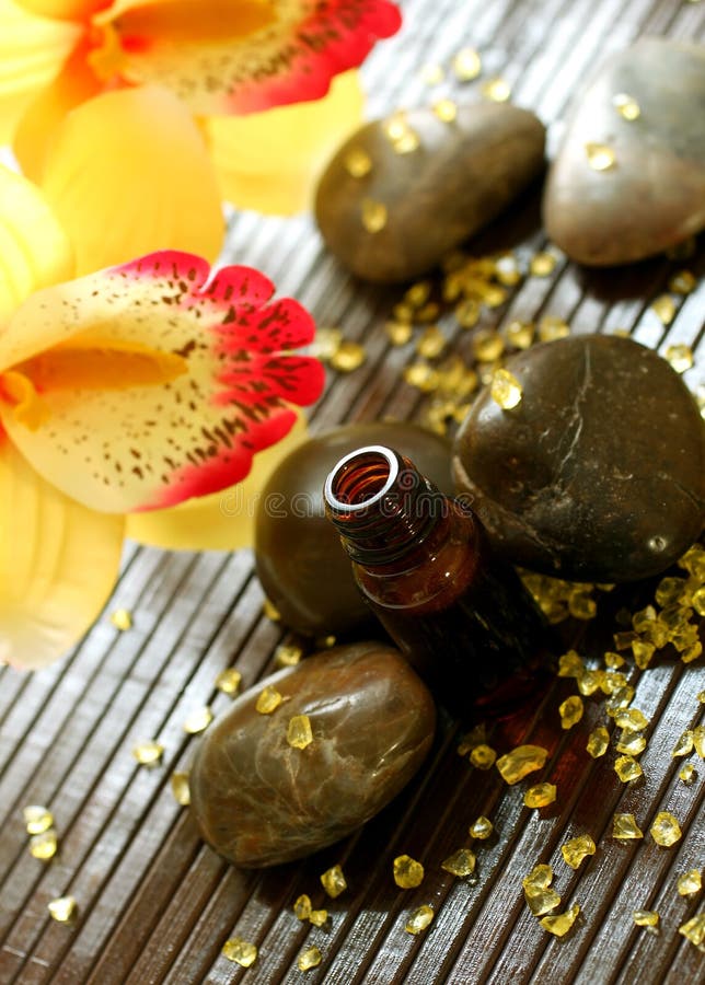 Bottle of essence oil, stones, bath salts and flow royalty free stock images