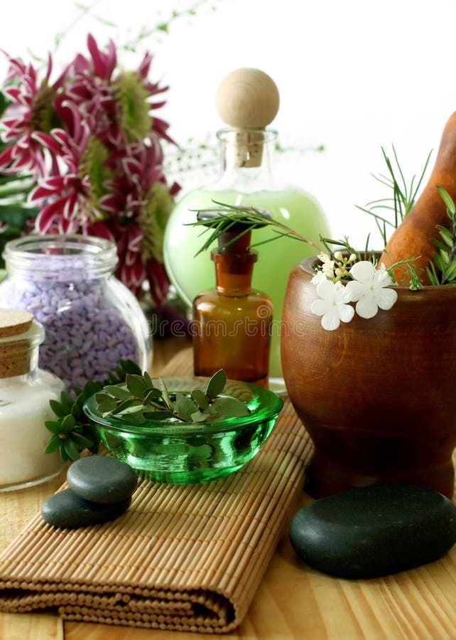 Bottle of essential oil, stones, mortar and flower