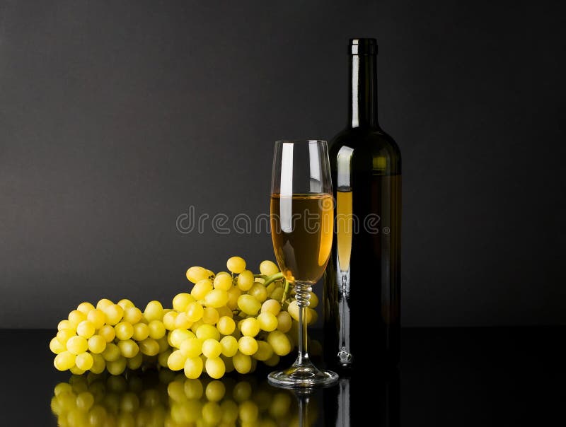 Bottle and glass of white wine with grapes