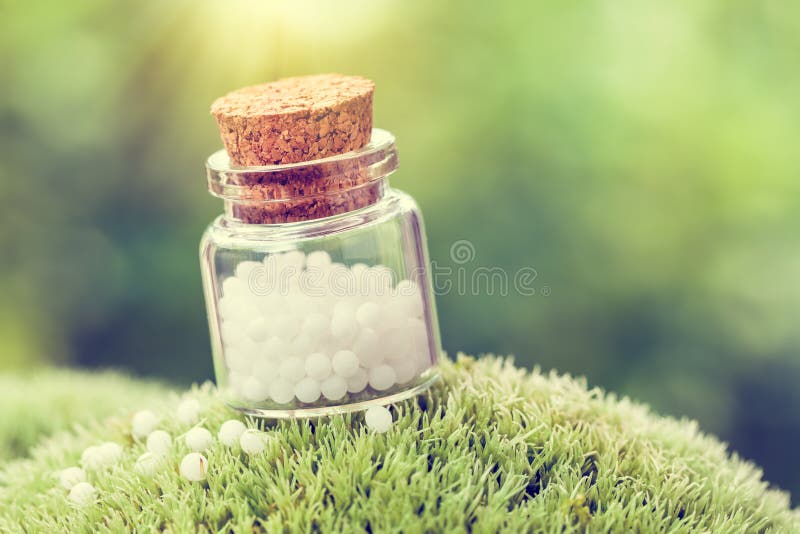 Bottle of white homeopathy globules on green moss. Retro styled. Green herbal drug medicine stock images, royalty-free photos and pictures