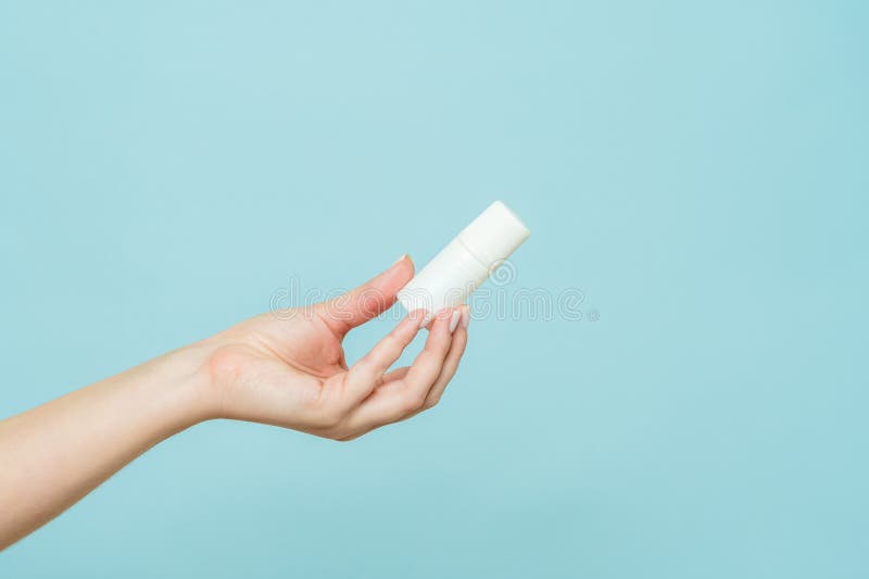 Bottle of Nasal Spray or Eye Drops in a Female Hand. Copy Space Stock