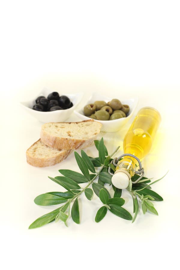 Bottle of olive oil with olives and branch