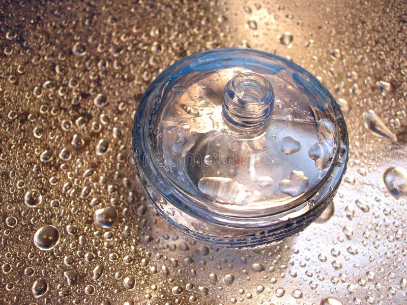 bottle of perfume on blue and silver background with drop of water