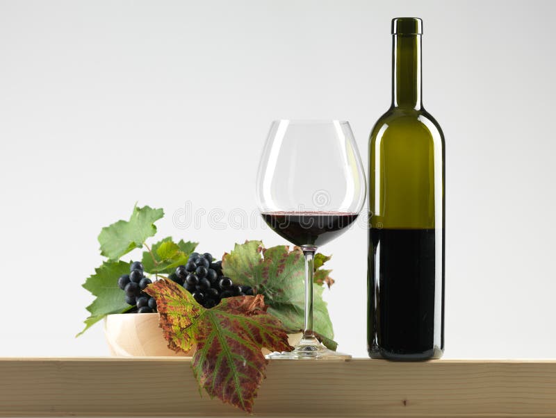 Bottle red wine, glass, grapes white background