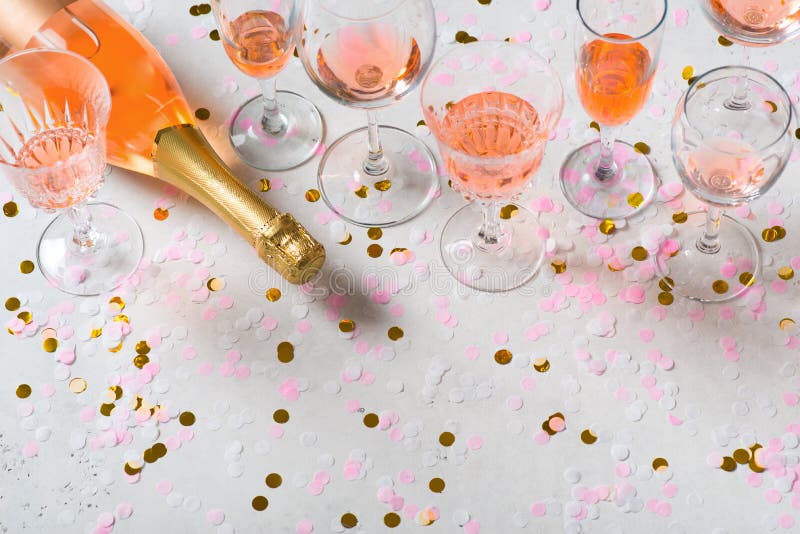 Bottle of Rose Sparkling Wine on Grey Background with Confetti Stock