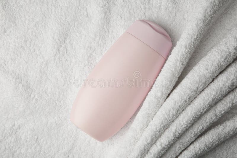 Bottle of shampoo on soft terry towel, top view royalty free stock images