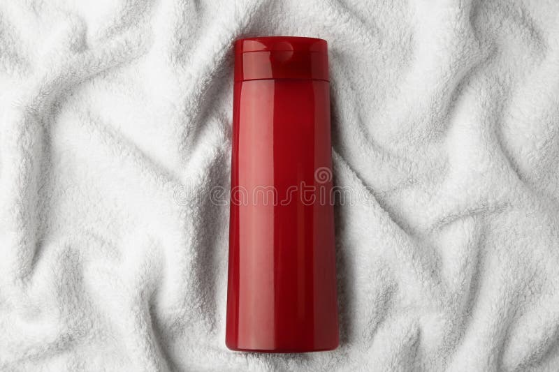 Bottle of shampoo on soft terry towel, top view stock image