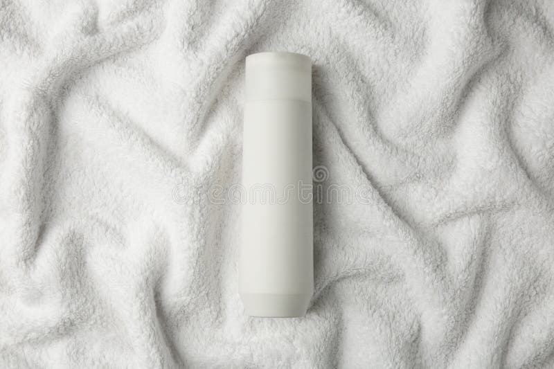 Bottle of shampoo on soft terry towel, top view stock image