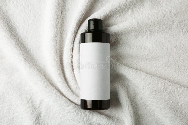 Bottle of shampoo on soft terry towel, top view royalty free stock photos