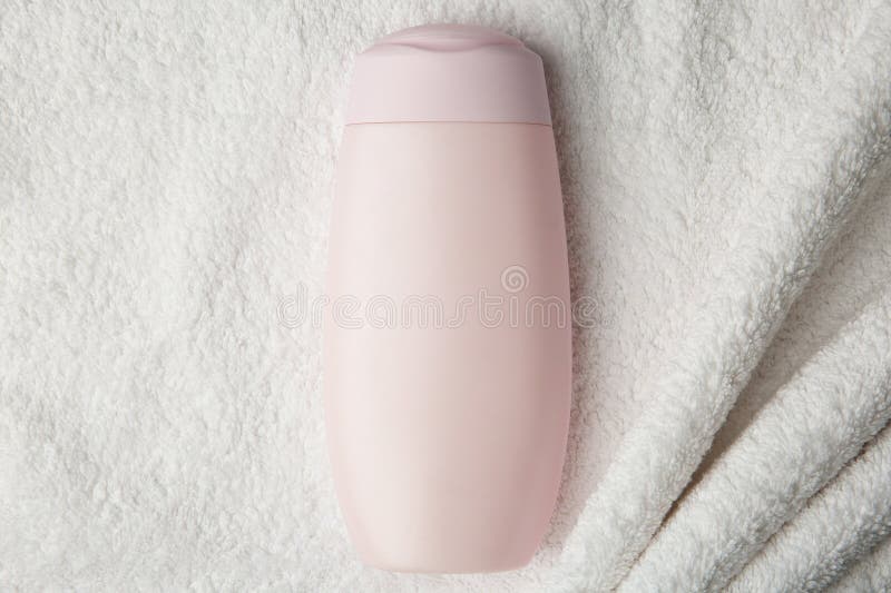 Bottle of shampoo on soft terry towel, top view royalty free stock image