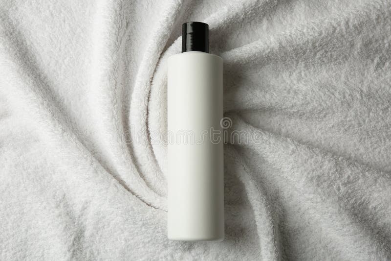 Bottle of shampoo on soft terry towel, top view royalty free stock images