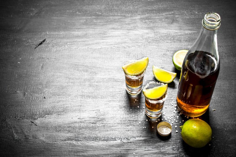 Bottle of Tequila with Shot Glasses, Fresh Lime and Salt. Stock Photo