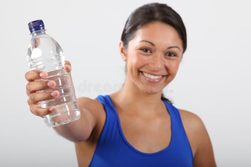 Beautiful teen girl holding bottle of water, smiling and drinking fresh  water Stock Photo