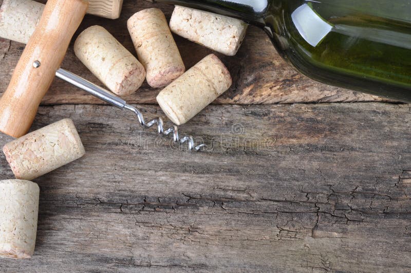 Bottle of white wine, corkscrew and corks on wooden table. stock images