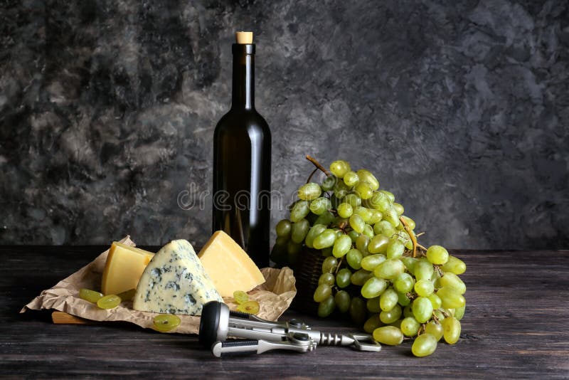 Bottle of wine with cheese and ripe grapes on wooden table royalty free stock photography Bottle of wine with cheese and ripe grapes on wooden table royalty free stock photography