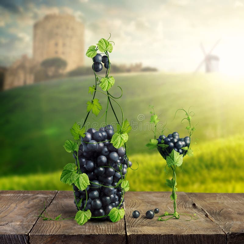 Bottle of Wine and a glass made by of grape leaves and a bunch of grapes on a wooden background