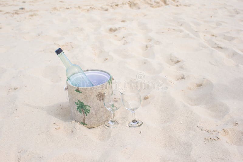 Bottle of White Wine and Two Glasses on the Exotic Sandy Beach Stock