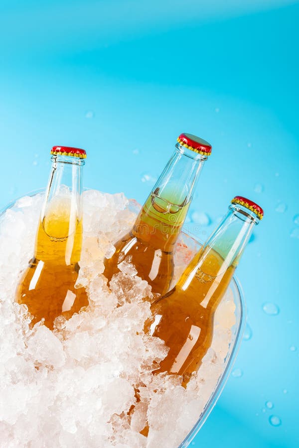 bottles of beer in an iced bucket on blue at vertical composition