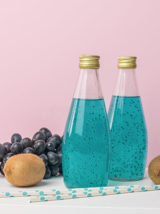 Bottles of Blue Cocktail with Basil Seeds on a Pink Background Stock