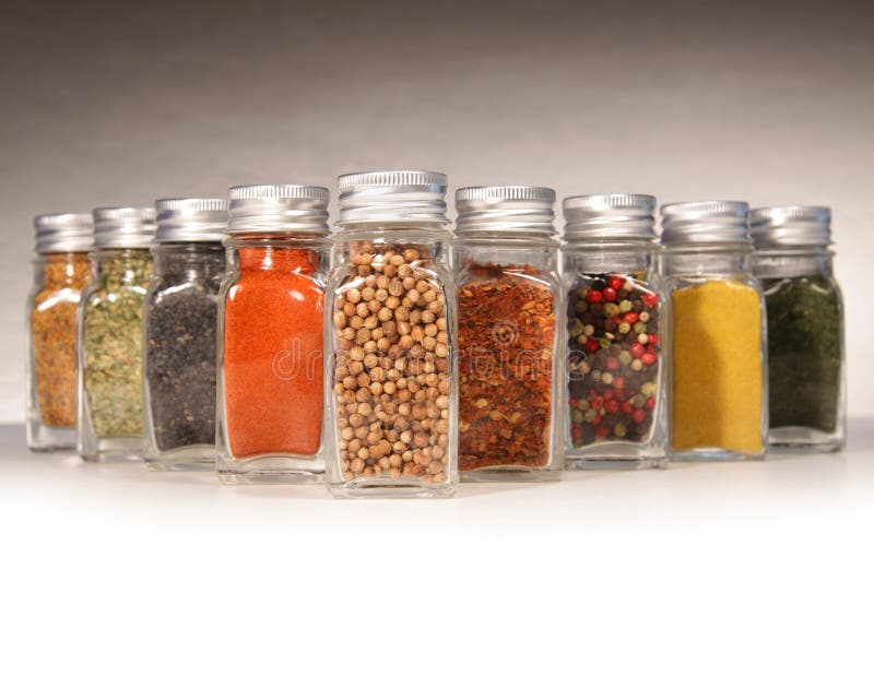 Bottles of colorful spices with grey