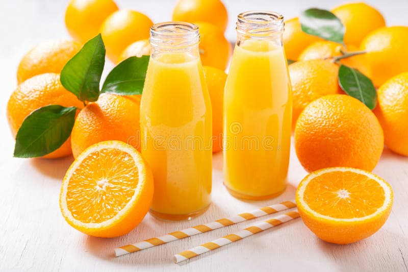 Bottles of fresh orange juice with fresh fruits