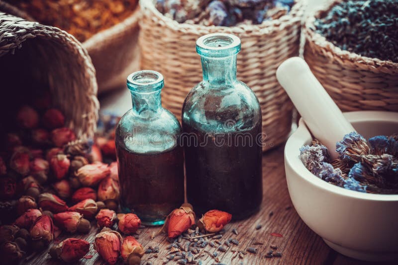 Bottles of tincture, basket with rose buds, and dried flowers