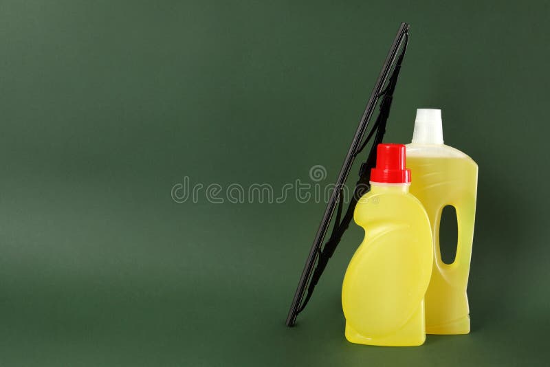 Bottles of Windshield Washer Fluids and Wiper on Dark Green