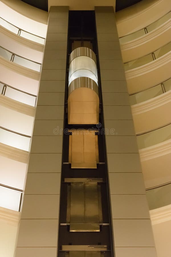 Bottom View of a Modern Glass Elevator Inside a Modern Building Stock