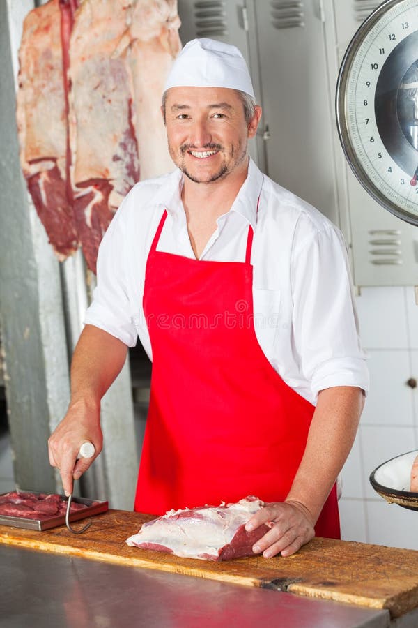 Boucher masculin With Red Meat à la boucherie photographie stock Boucher masculin With Red Meat à la boucherie photographie stock