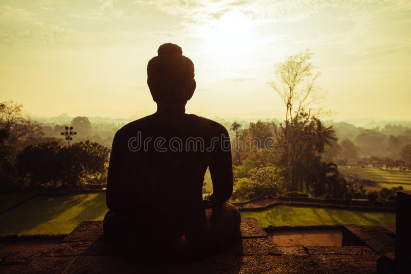 Bouddha méditant pendant le matin, temple de Borobudur photo libre de droits Bouddha méditant pendant le matin, temple de Borobudur photo libre de droits