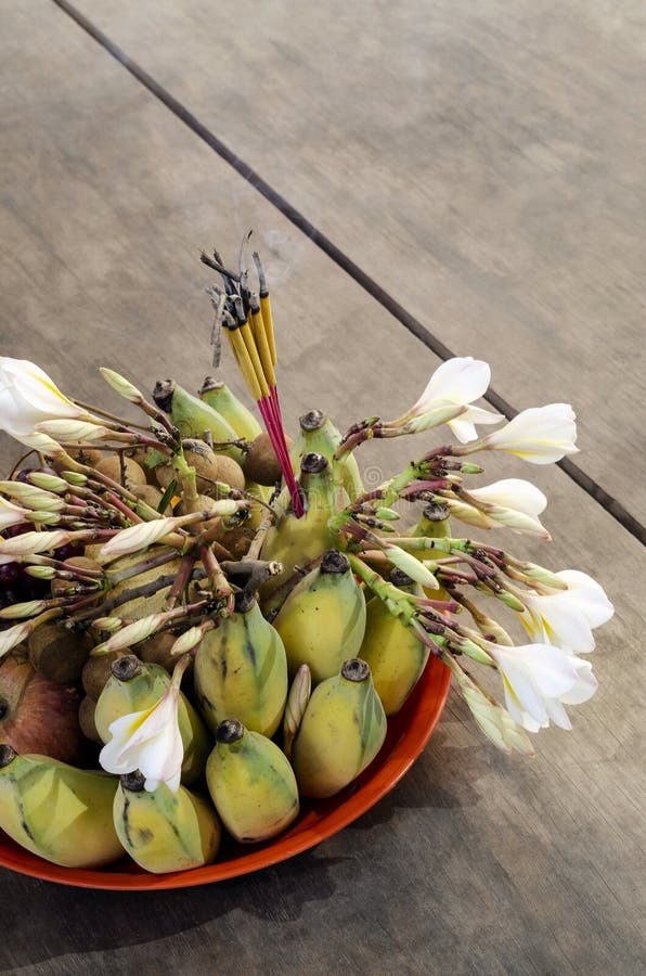 Bouddhiste offrant bol avec encens fruits et fleurs détail en thaïlande