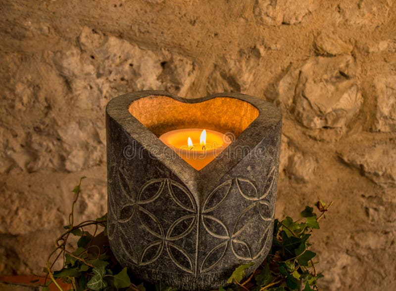 Image with a big stoned candle holder, artistic engraved and a heart shaped candle light. Image with a big stoned candle holder, artistic engraved and a heart shaped candle light.