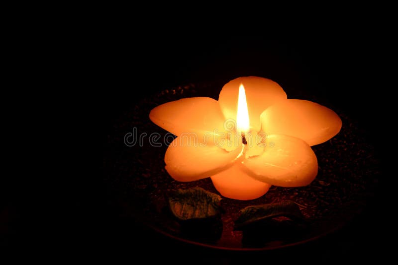 bougie en forme de fleur brûlant sur un fond noir images stock bougie en forme de fleur brûlant sur un fond noir images stock