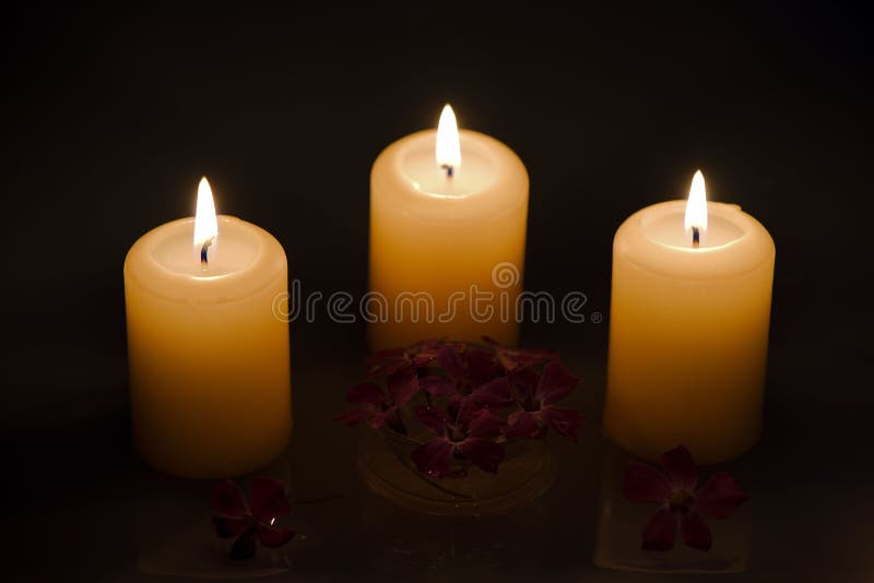 Bougies brûlantes avec des fleurs dans l'eau photo stock Bougies brûlantes avec des fleurs dans l'eau photo stock