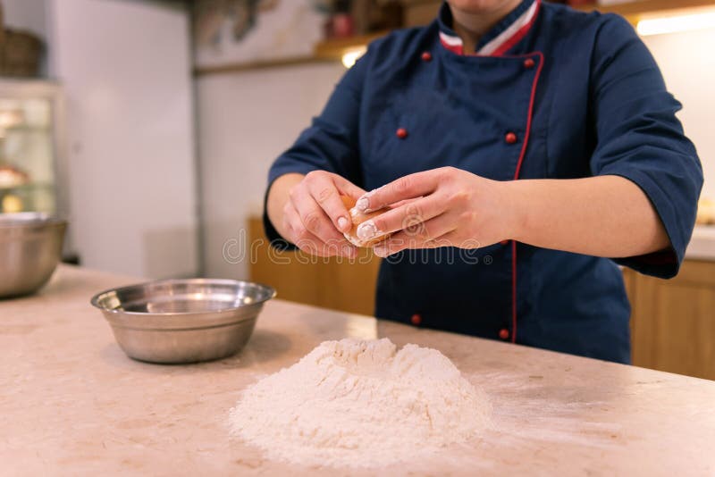 Hard-working baker. Hard-working baker wearing blue jacket making dough for croissants early in the morning. Hard-working baker. Hard-working baker wearing blue jacket making dough for croissants early in the morning