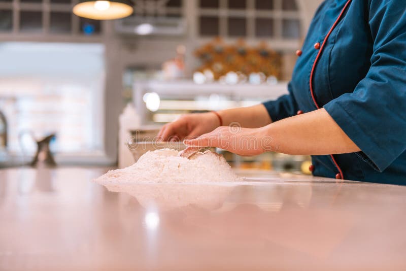 Dough for croissants. Hard-working experienced baker wearing blue jacket making dough for croissants. Dough for croissants. Hard-working experienced baker wearing blue jacket making dough for croissants