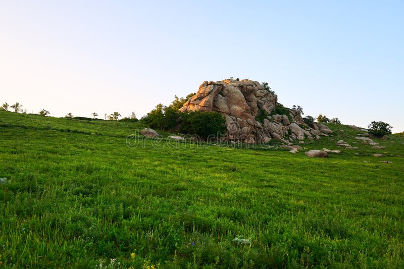 The boulder rock on the grassland sunset