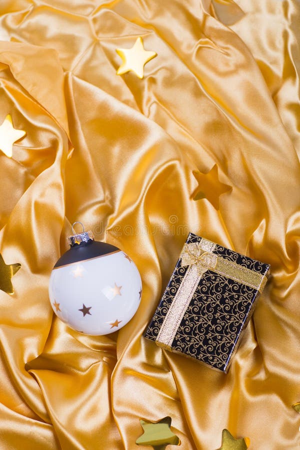 Boule noire et blanche élégante de Noël avec les étoiles et le boîte-cadeau sur le tissu d'or de satin photographie stock libre de droits Boule noire et blanche élégante de Noël avec les étoiles et le boîte-cadeau sur le tissu d'or de satin photographie stock libre de droits