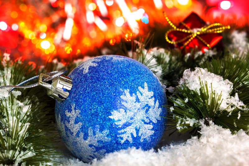 Boule sur les branches neigeuses d'un arbre de Noël sur un fond de tresse brillante Lumières rougeoyantes photo stock Boule sur les branches neigeuses d'un arbre de Noël sur un fond de tresse brillante Lumières rougeoyantes photo stock