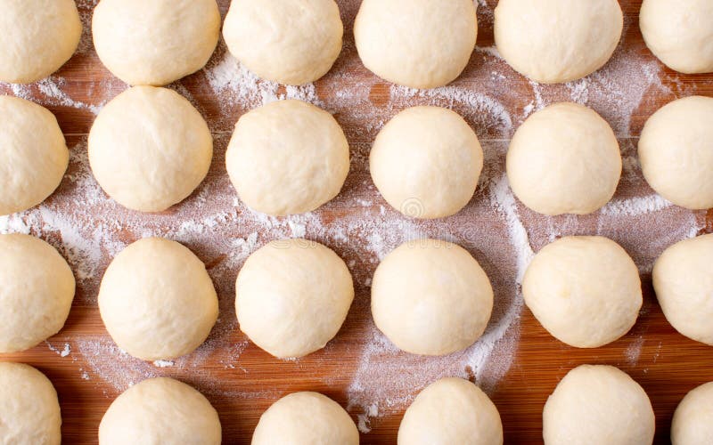 Boules de pâte à levures sur le panneau en bois. Boules de pâte à levure sur le panneau en bois avec de la farine. préparation de la cuisson des petits pains pizza ou pain. vue supérieure