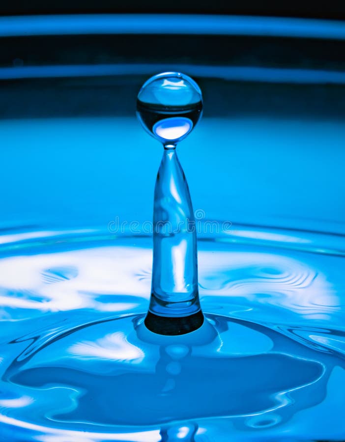 Blue liquid droplet bounding from to the pool of pure water. High speed photography image. Blue liquid droplet bounding from to the pool of pure water. High speed photography image.