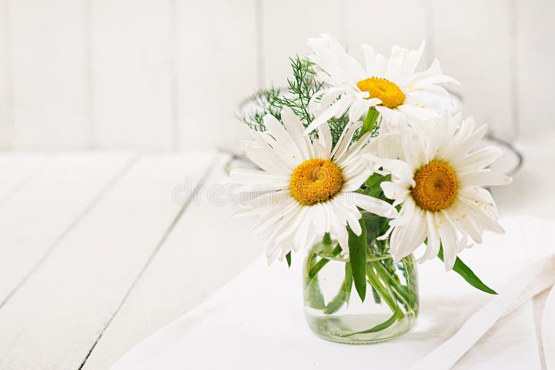 Bouquet of daisies in vase on a wooden