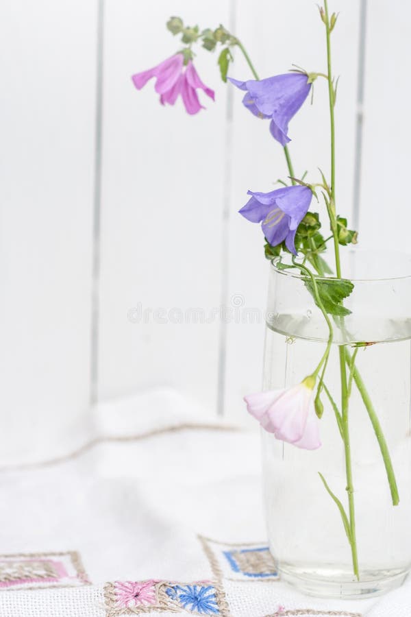 Bouquet De Campanula De Flores Silvestres Num Vaso De Vidro Sobre Uma  Toalha Bordada Em Fundo Branco De Madeira Foto de Stock - Imagem de  florista, narcotize: 189643702