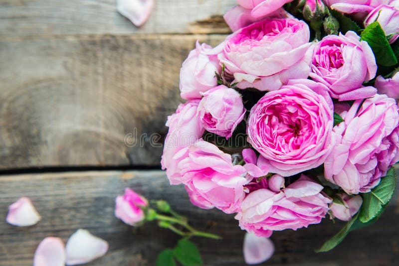 Bouquet de roses de thé rose d'offre de vue supérieure sur la table en bois rustique de vintage avec des pétales Fond floral Moqu image libre de droits Bouquet de roses de thé rose d'offre de vue supérieure sur la table en bois rustique de vintage avec des pétales Fond floral Moqu image libre de droits
