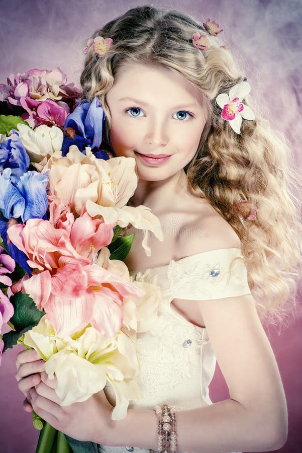 Beautiful tender girl in white festive dress holds bouquet of flowers. Over pink background.