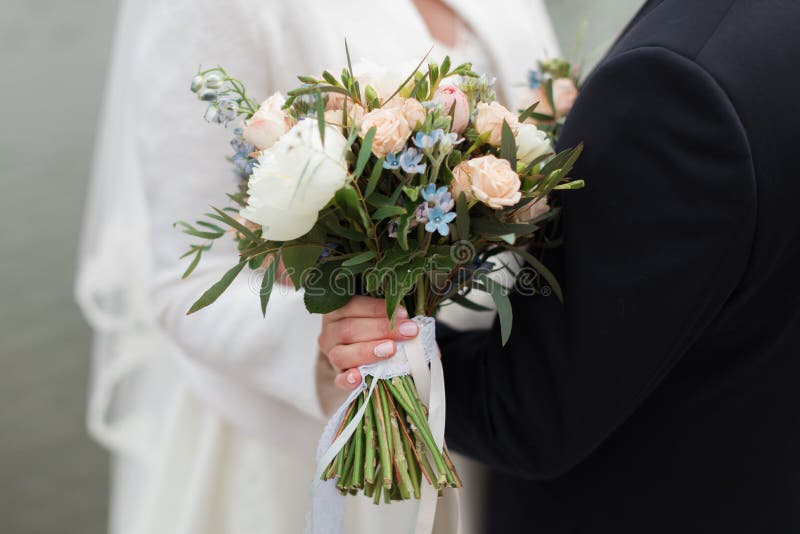 Bouquet nuziale nella mano della sposa immagine stock Bouquet nuziale nella mano della sposa immagine stock