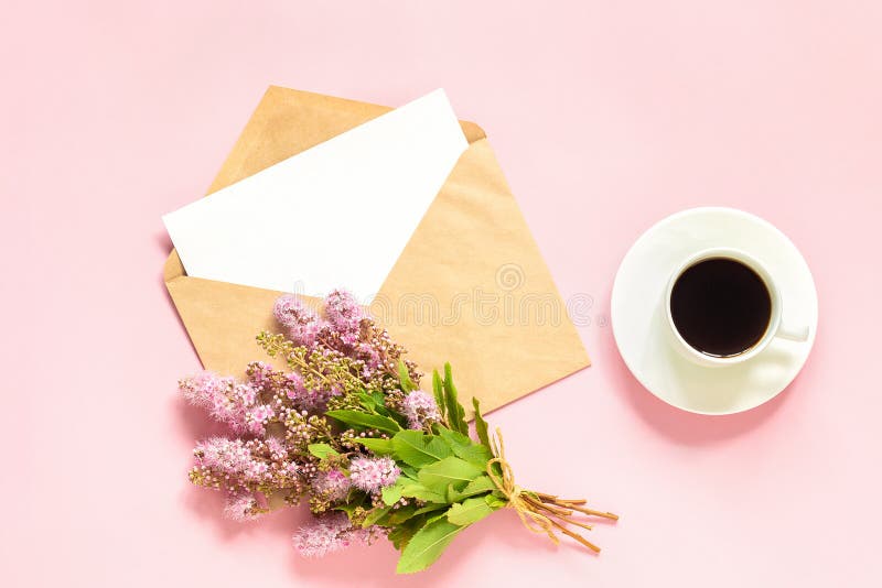 Bouquet of pink flowers, envelope with white blank card for text and cup of coffee on pink background Greeting card Flat Lay Mock