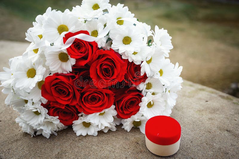 A Bouquet of Red Roses and Daisies and a Box with a Gold Ring Stock